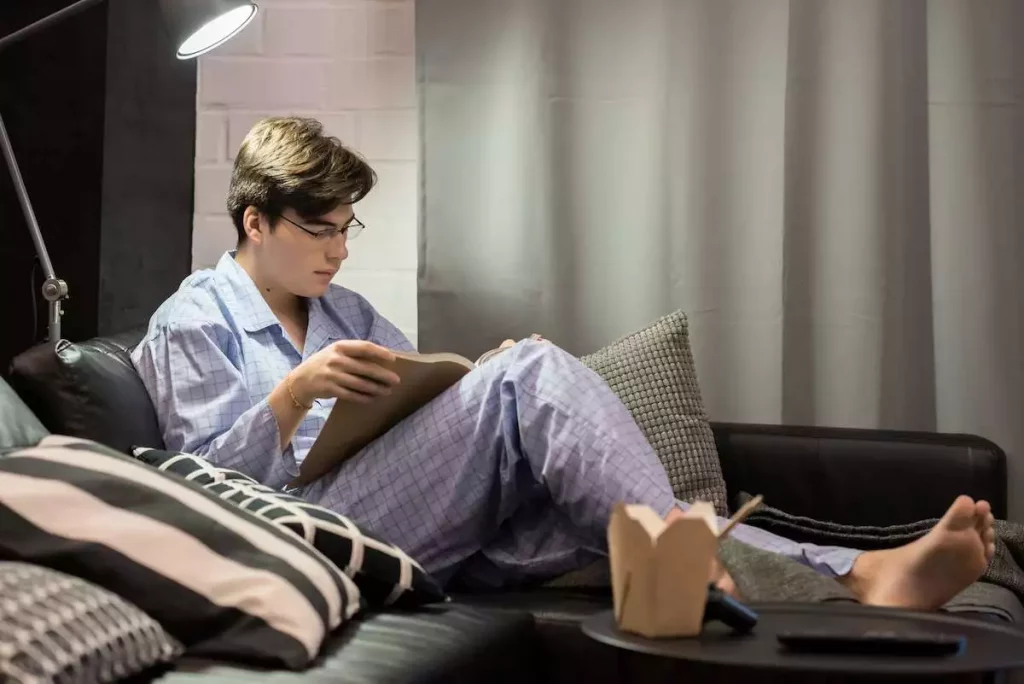 young boy or a man reading a book in his pyjamas