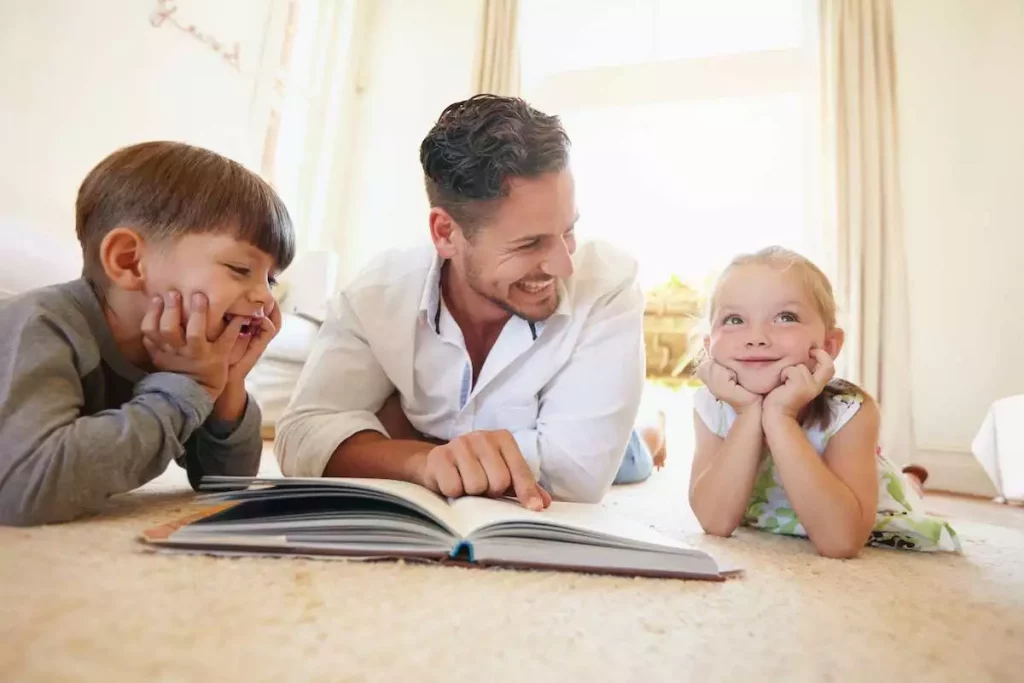 Father reading a story book to his two kids as they image