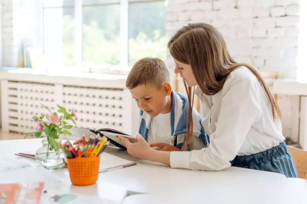 a speech therapist helping a child to overcome the problem of stuttering by helping him read